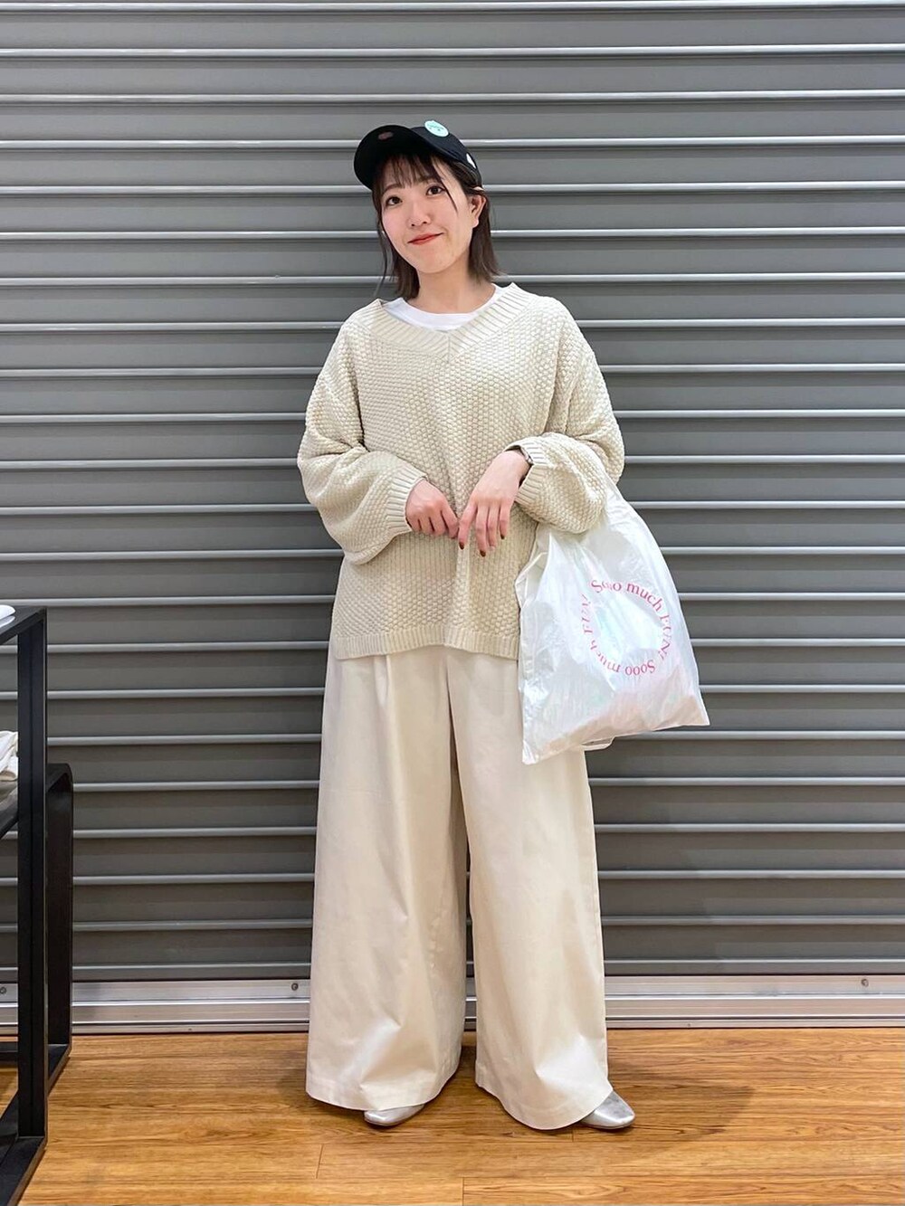 グレー系のパンプス、ホワイト系のニット/セーター、ホワイト系のTシャツ/カットソーを着用したレディースの春コーディネートの2枚目の写真