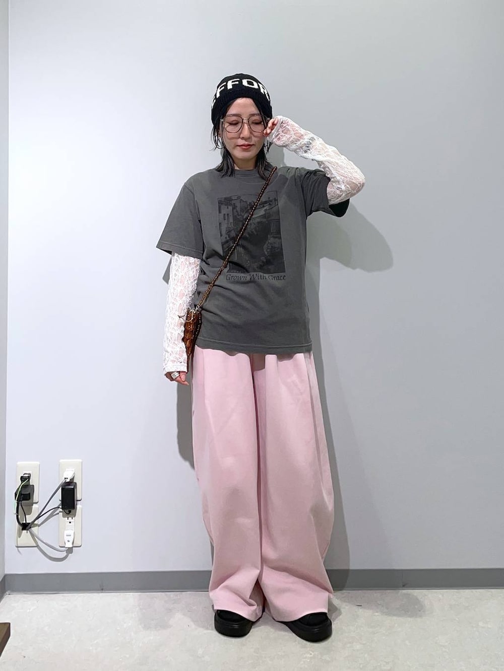 ホワイト系のTシャツ/カットソー、ブラック系のサンダル、ブラウン系のショルダーバッグを着用したレディースの春コーディネートの2枚目の写真