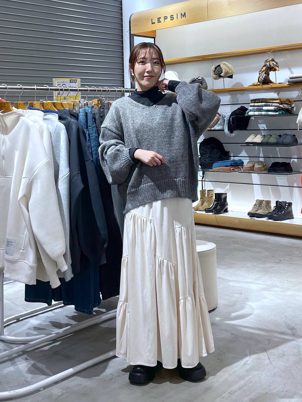 ブラック系のブーツ、グレー系のニット/セーター、ブラック系のTシャツ/カットソーを着用したレディースの秋コーディネートの2枚目の写真