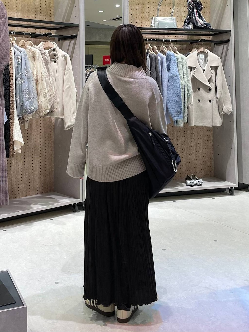 ブラック系のショルダーバッグ、ベージュ系のワンピースを着用したレディースの冬コーディネートの5枚目の写真