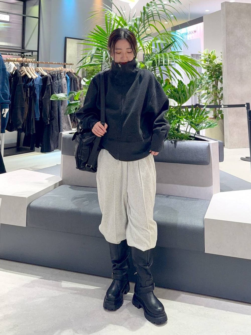 グレー系のスウェット、グレー系のその他パンツ、ブラック系のブーツを着用したレディースの秋コーディネートの2枚目の写真