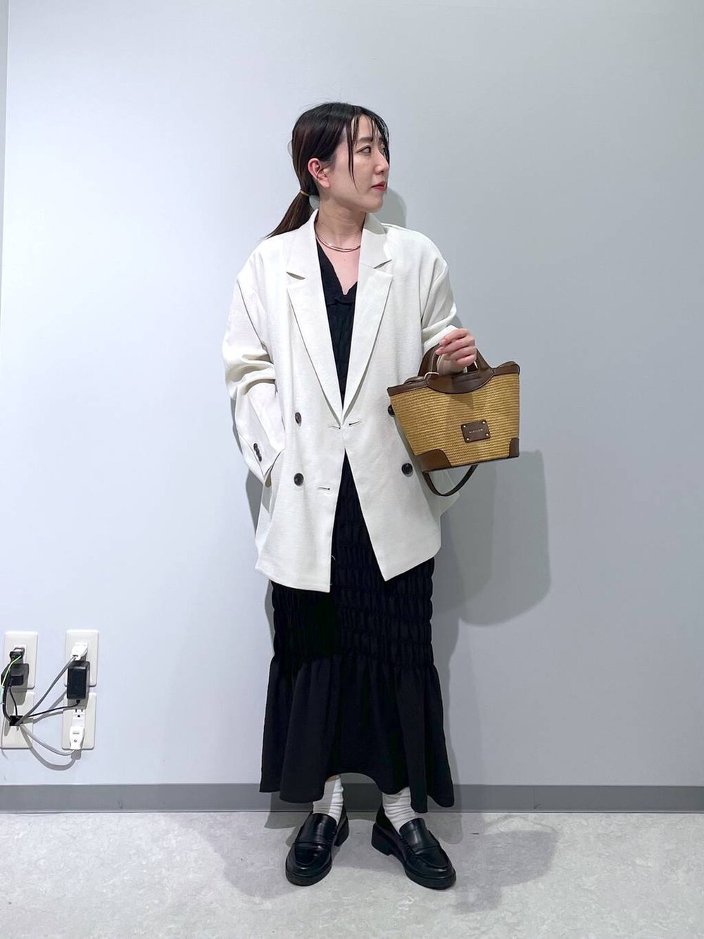 ホワイト系のテーラードジャケット、ブラウン系のショルダーバッグ、ブラック系のワンピースを着用したレディースの春コーディネートの5枚目の写真