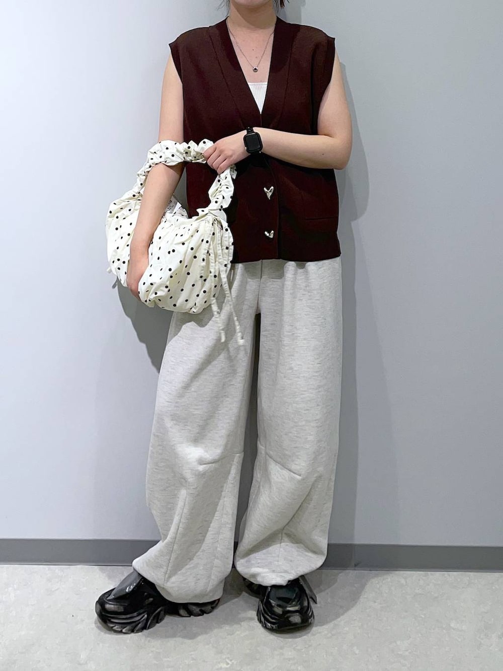 ブラック系のスニーカー、グレー系のスウェットパンツ、ブラウン系のベストを着用したレディースの夏コーディネートの2枚目の写真