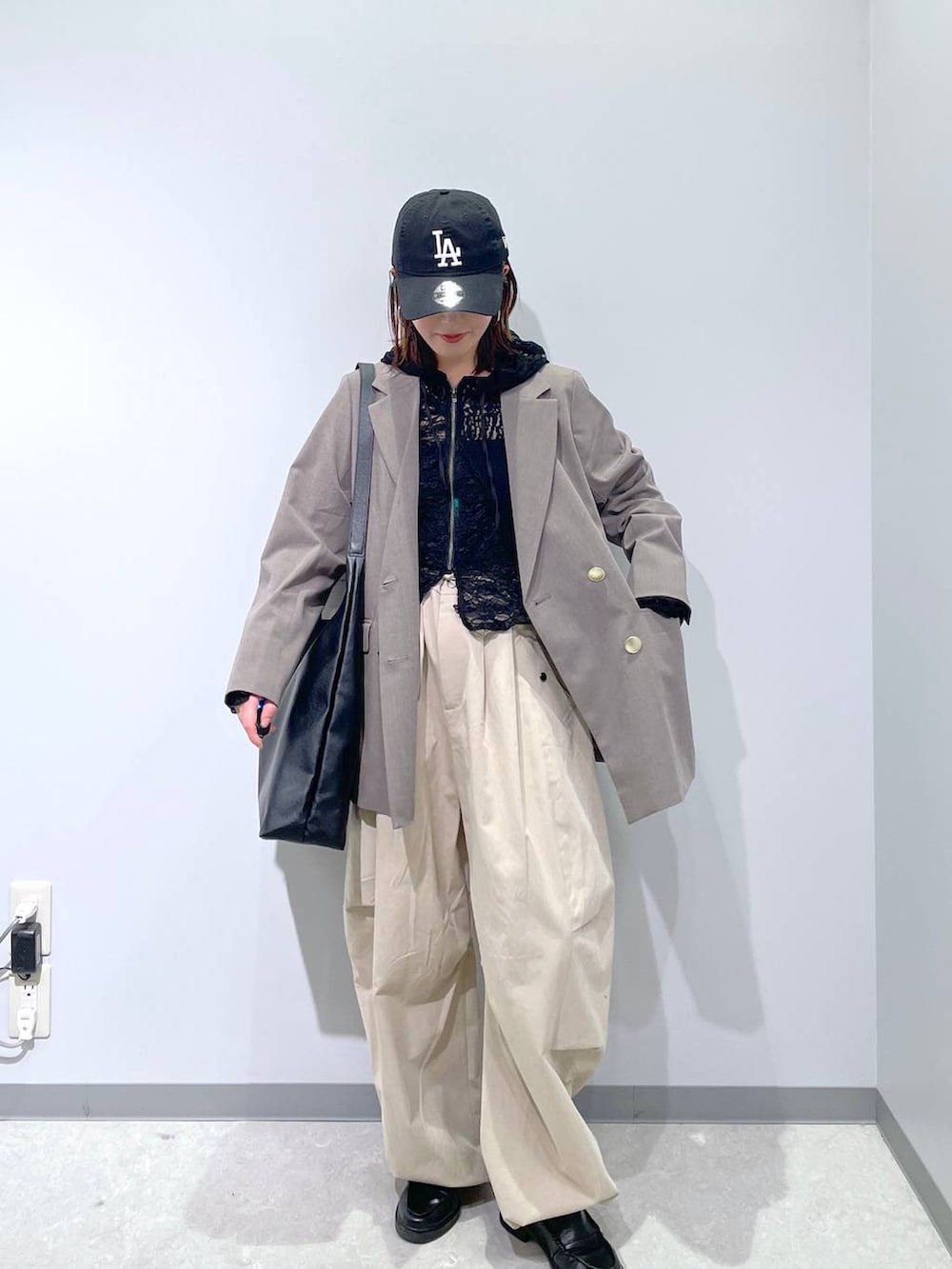 ブラック系のショルダーバッグ、ブラウン系のテーラードジャケット、ブラック系のパーカーを着用したレディースの春コーディネートの4枚目の写真