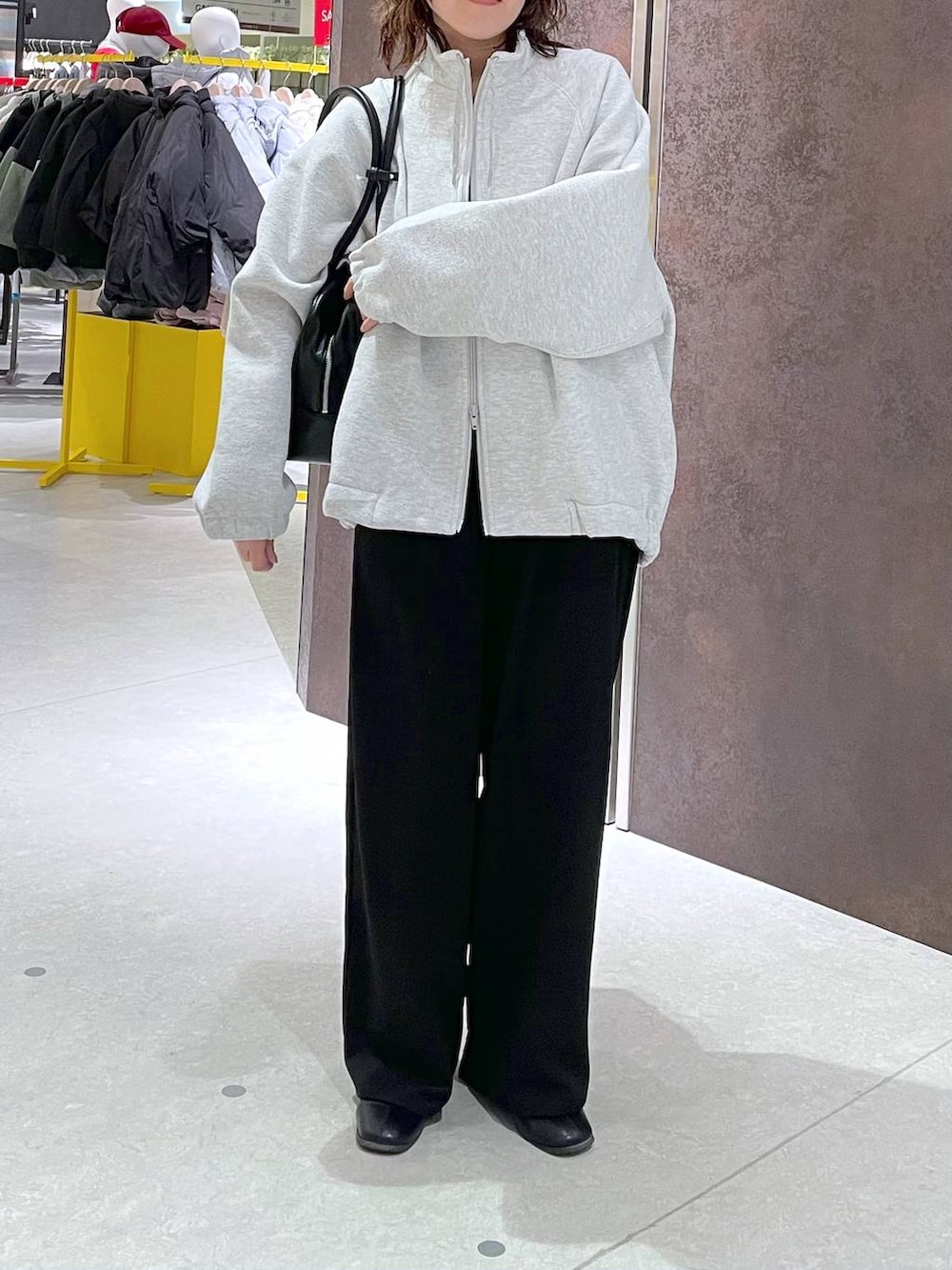 グレー系のブルゾン、ブラック系のサロペット/オーバーオール、ブラック系のボストンバッグを着用したレディースの冬コーディネートの4枚目の写真