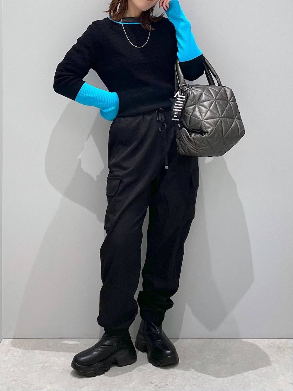 ブラック系のブルゾン、ブラック系のトートバッグ、ブラック系のカーゴパンツを着用したレディースの冬コーディネートの8枚目の写真