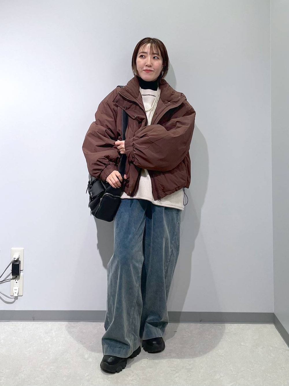 ブラウン系のその他アウター、ブラック系のニット/セーター、ブルー系のその他パンツを着用したレディースの冬コーディネートの3枚目の写真