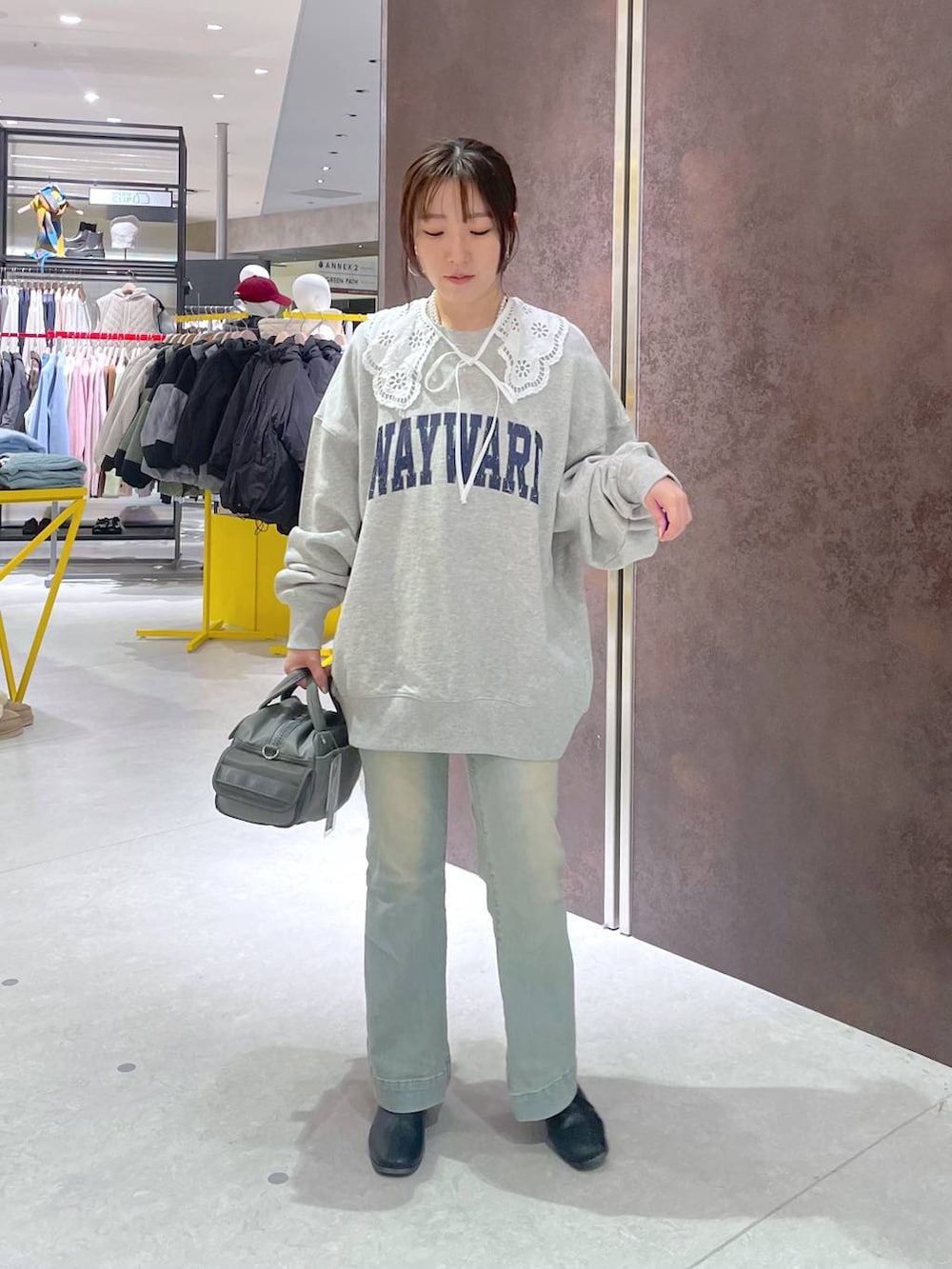 グリーン系のボストンバッグ、グレー系のスウェットを着用したレディースの冬コーディネートの3枚目の写真