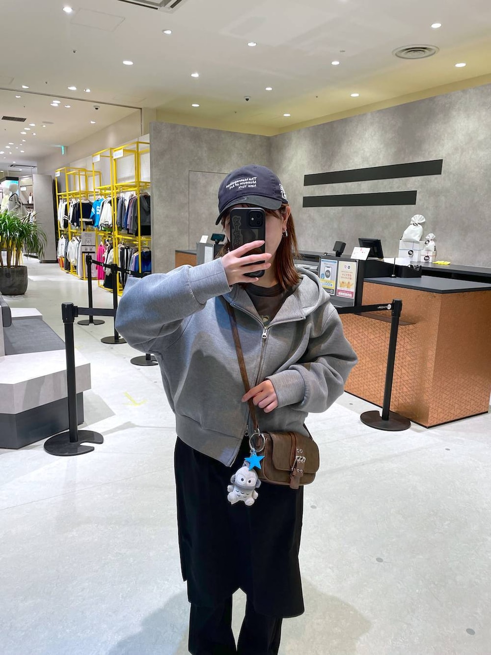 グリーン系のショルダーバッグ、ブラック系のその他パンツ、ブルー系のキャップを着用したレディースの冬コーディネートの2枚目の写真