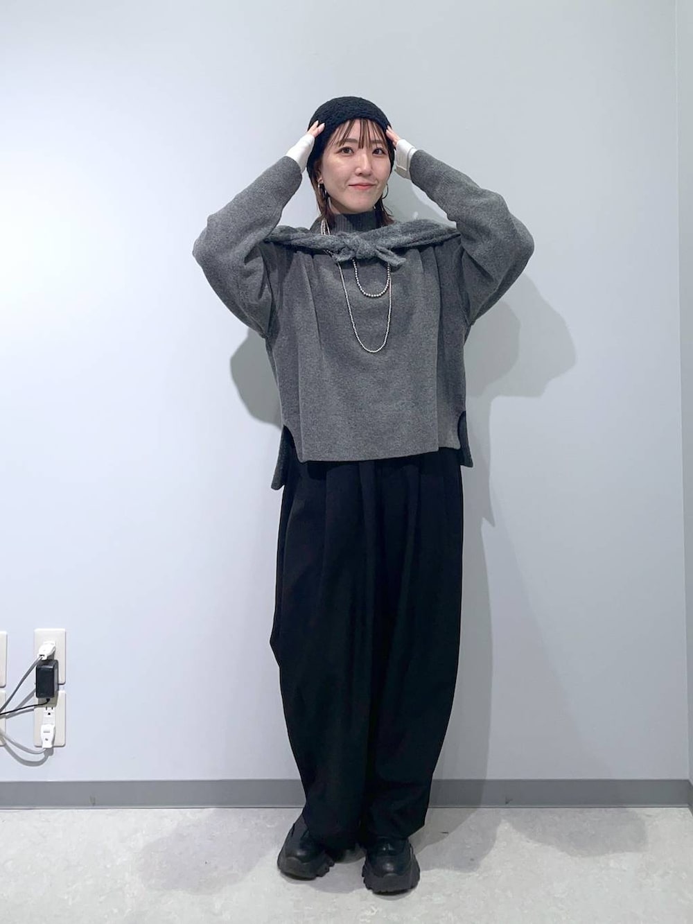 グレー系のニット/セーター、シルバー系のネックレス、グレー系のストール/ショールを着用したレディースの冬コーディネートの2枚目の写真