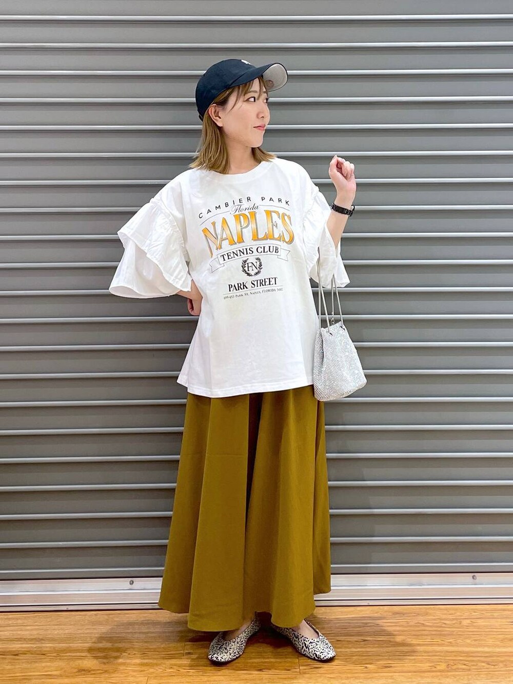 シルバー系のショルダーバッグ、グリーン系のその他パンツ、シルバー系のパンプスを着用したレディースの夏コーディネートの2枚目の写真
