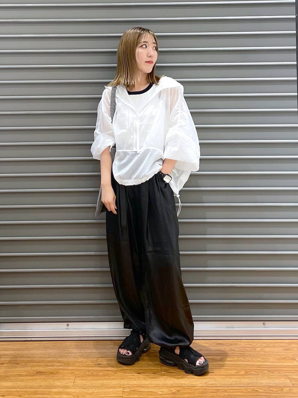 シルバー系のトートバッグ、ブラック系のその他パンツ、ホワイト系のパーカーを着用したレディースの秋コーディネートの2枚目の写真