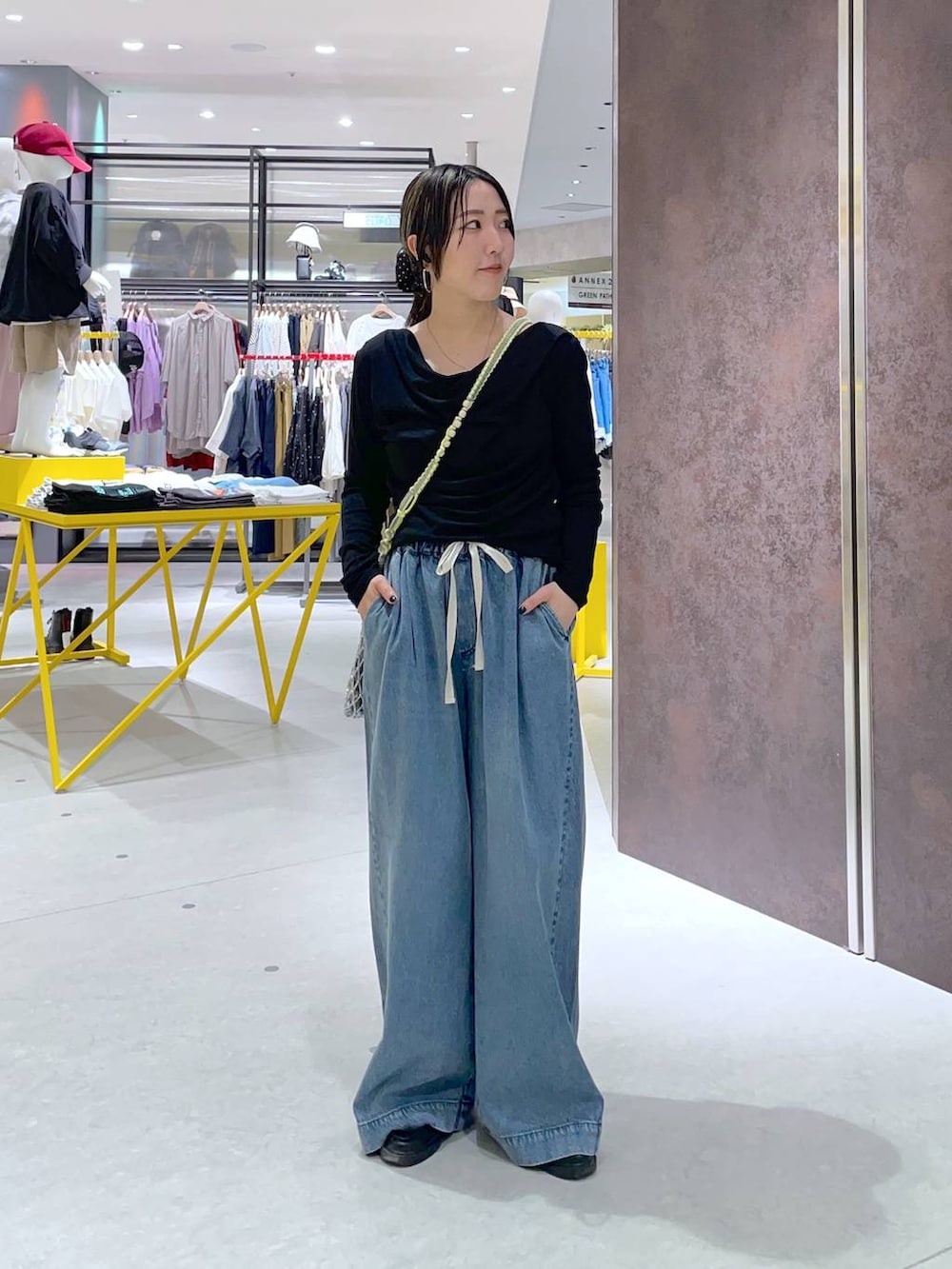 ブルー系のデニムパンツ、シルバー系のトートバッグを着用したレディースの春コーディネートの2枚目の写真