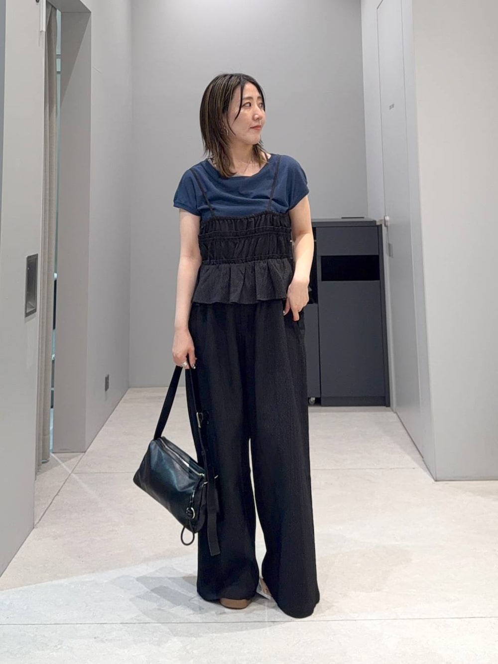 ブルー系のTシャツ/カットソー、ブラック系のサンダル、ブラック系のショルダーバッグを着用したレディースの夏コーディネートの2枚目の写真