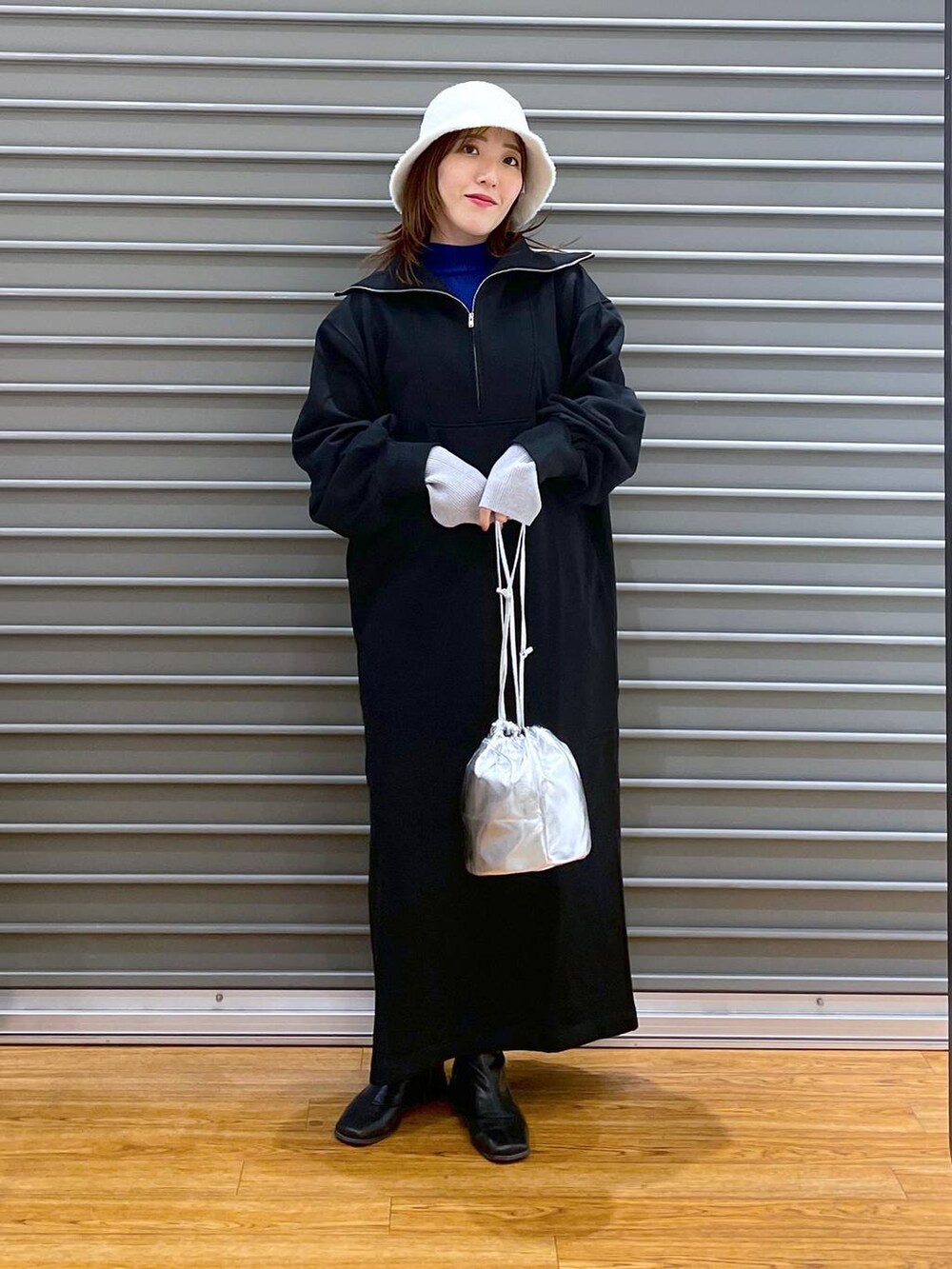 ブラック系のワンピース、シルバー系のショルダーバッグ、ブルー系のニット/セーターを着用したレディースの冬コーディネートの3枚目の写真