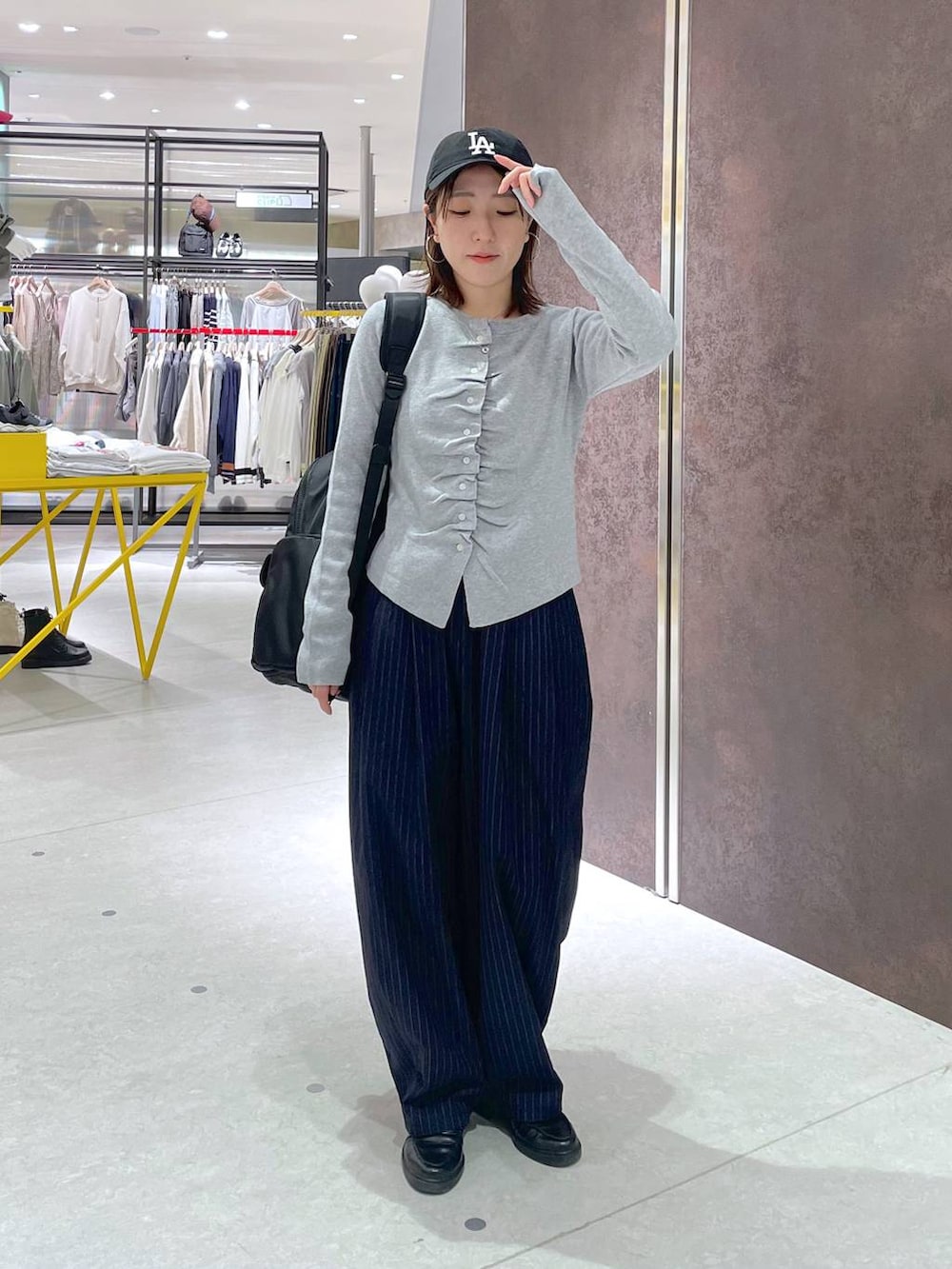 ブルー系のその他パンツ、ブラック系のバックパック/リュック、グレー系のカーディガン/ボレロを着用したレディースの春コーディネートの4枚目の写真