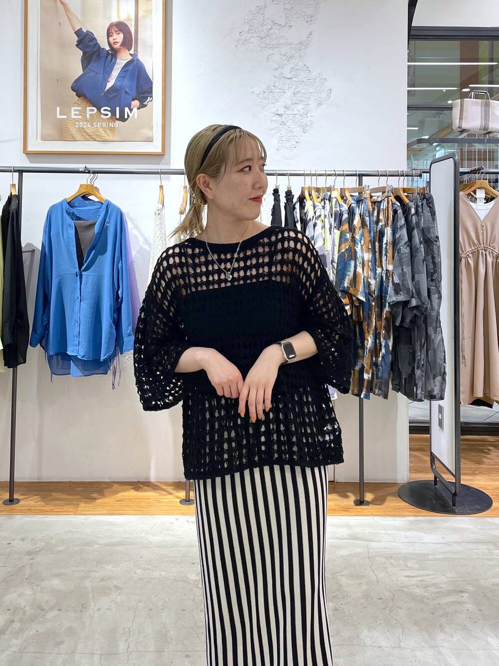 ホワイト系のスカート、パープル系のニット/セーター、シルバー系のネックレスを着用したレディースの春コーディネートの3枚目の写真