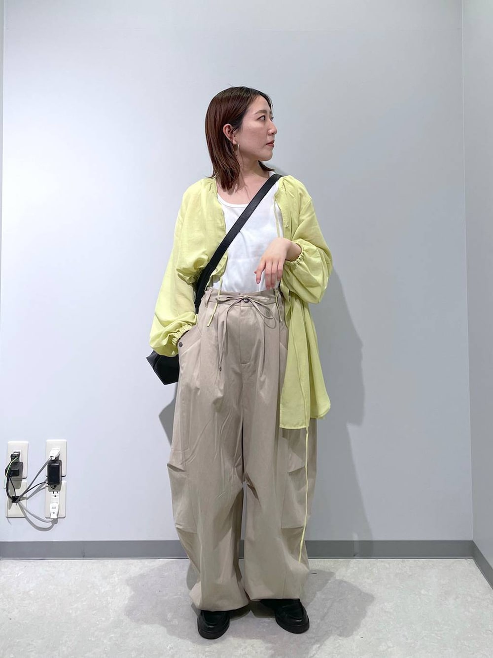 ブラック系のショルダーバッグ、イエロー系のシャツ/ブラウス、ベージュ系のその他パンツを着用したレディースの春コーディネートの3枚目の写真