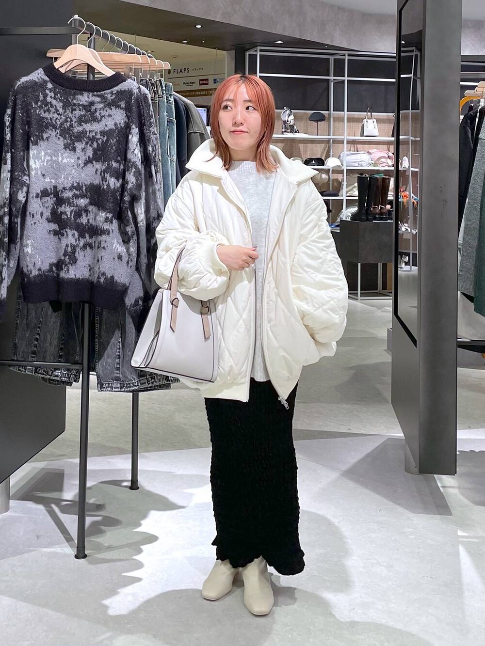 グレー系のニット/セーター、ホワイト系のブーツ、ホワイト系のブルゾンを着用したレディースの秋コーディネートの2枚目の写真