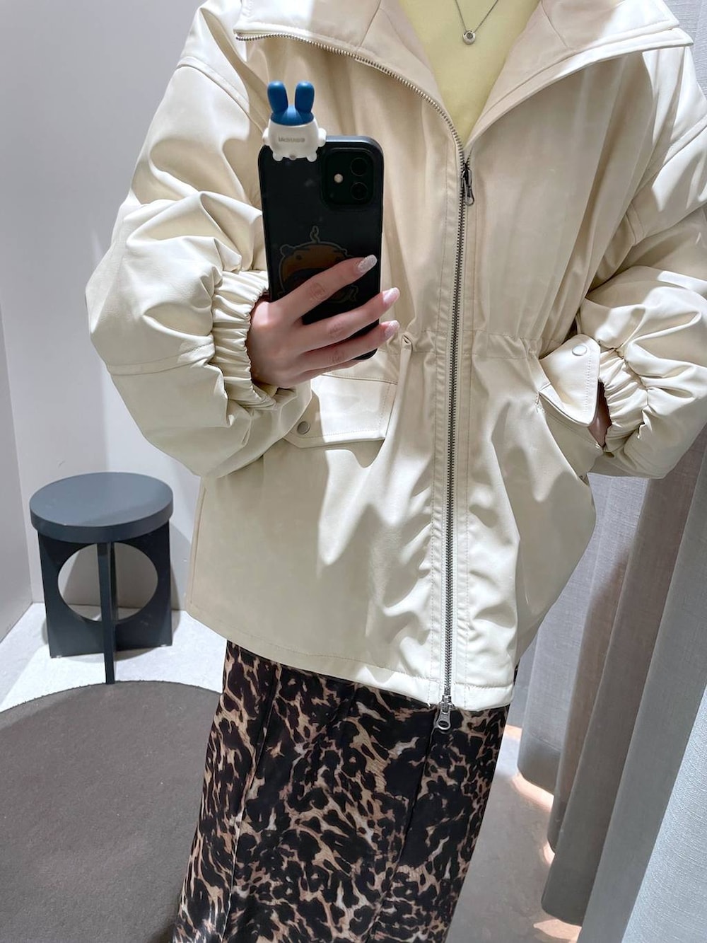 ブラウン系のスカート、ホワイト系のブルゾン、イエロー系のスウェットを着用したレディースの冬コーディネートの5枚目の写真