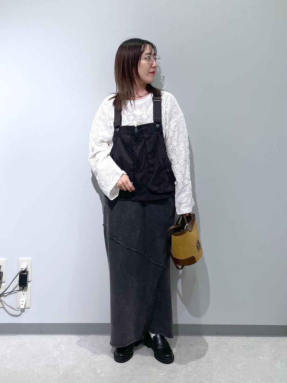 グレー系のベスト、ブラック系のスカート、ホワイト系のTシャツ/カットソーを着用したレディースの春コーディネートの3枚目の写真