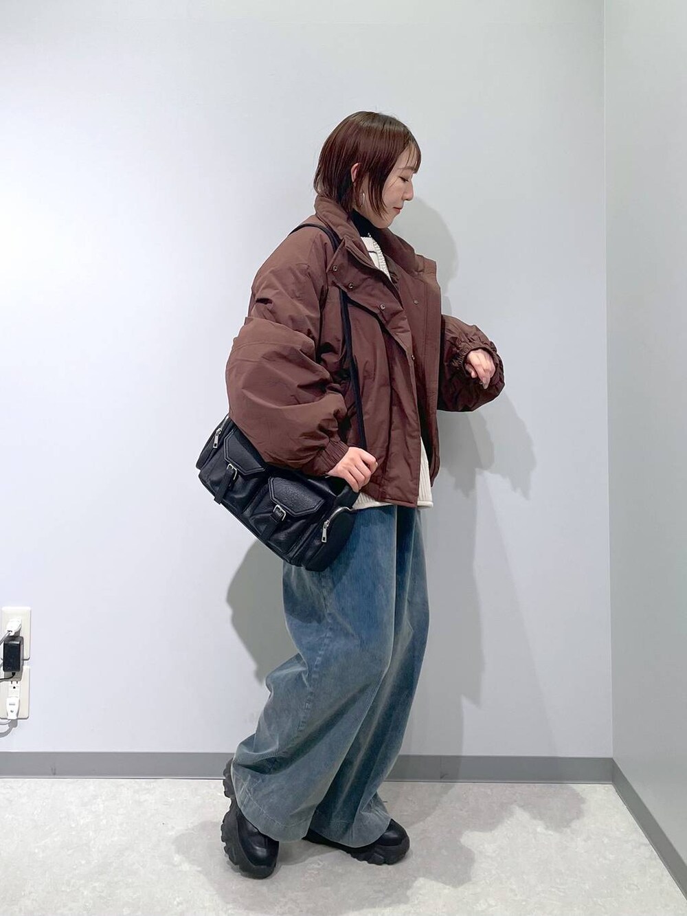 ブラウン系のその他アウター、ブラック系のニット/セーター、ブルー系のその他パンツを着用したレディースの冬コーディネートの2枚目の写真