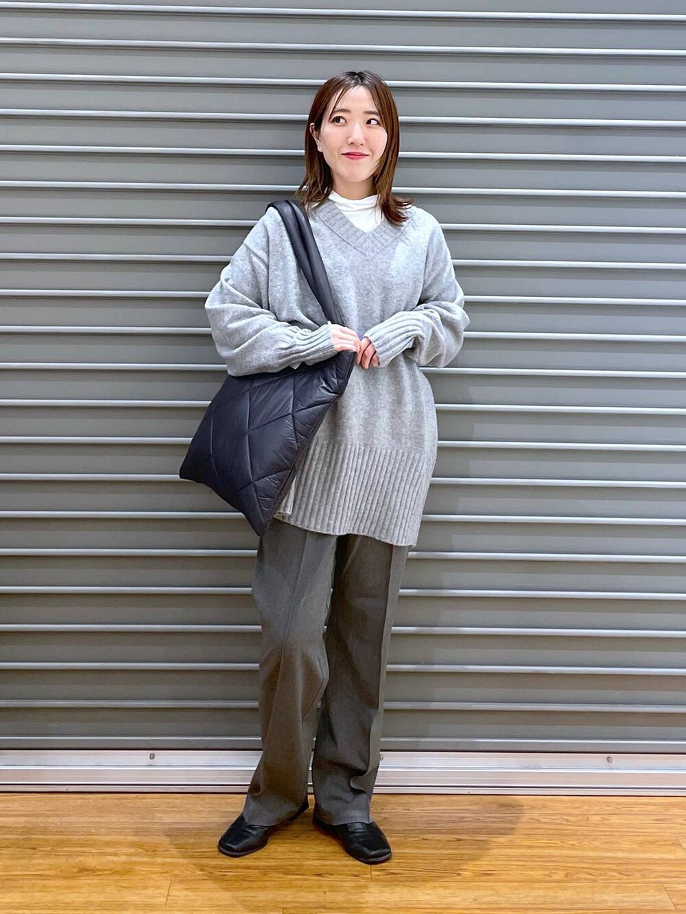 グレー系のその他パンツ、ブラック系のトートバッグ、グレー系のニット/セーターを着用したレディースの冬コーディネートの2枚目の写真