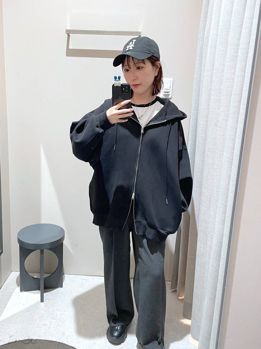 ブラック系のパーカー、ブラック系のキャップを着用したレディースの冬コーディネートの4枚目の写真