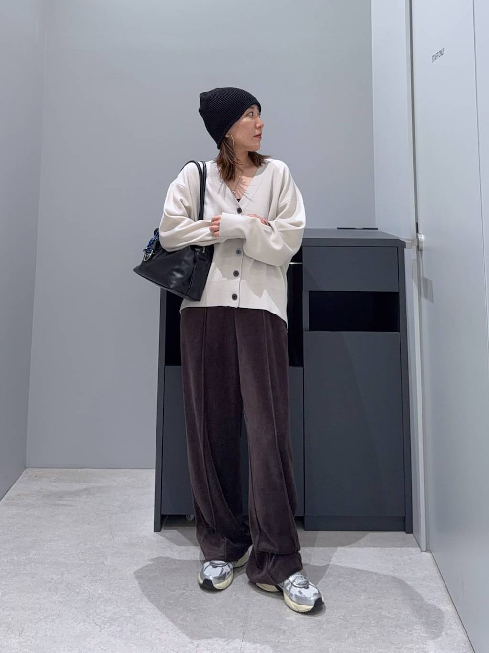 ブラック系のボストンバッグ、ベージュ系のカーディガン/ボレロ、ブラウン系のその他パンツを着用したレディースの秋コーディネートの2枚目の写真