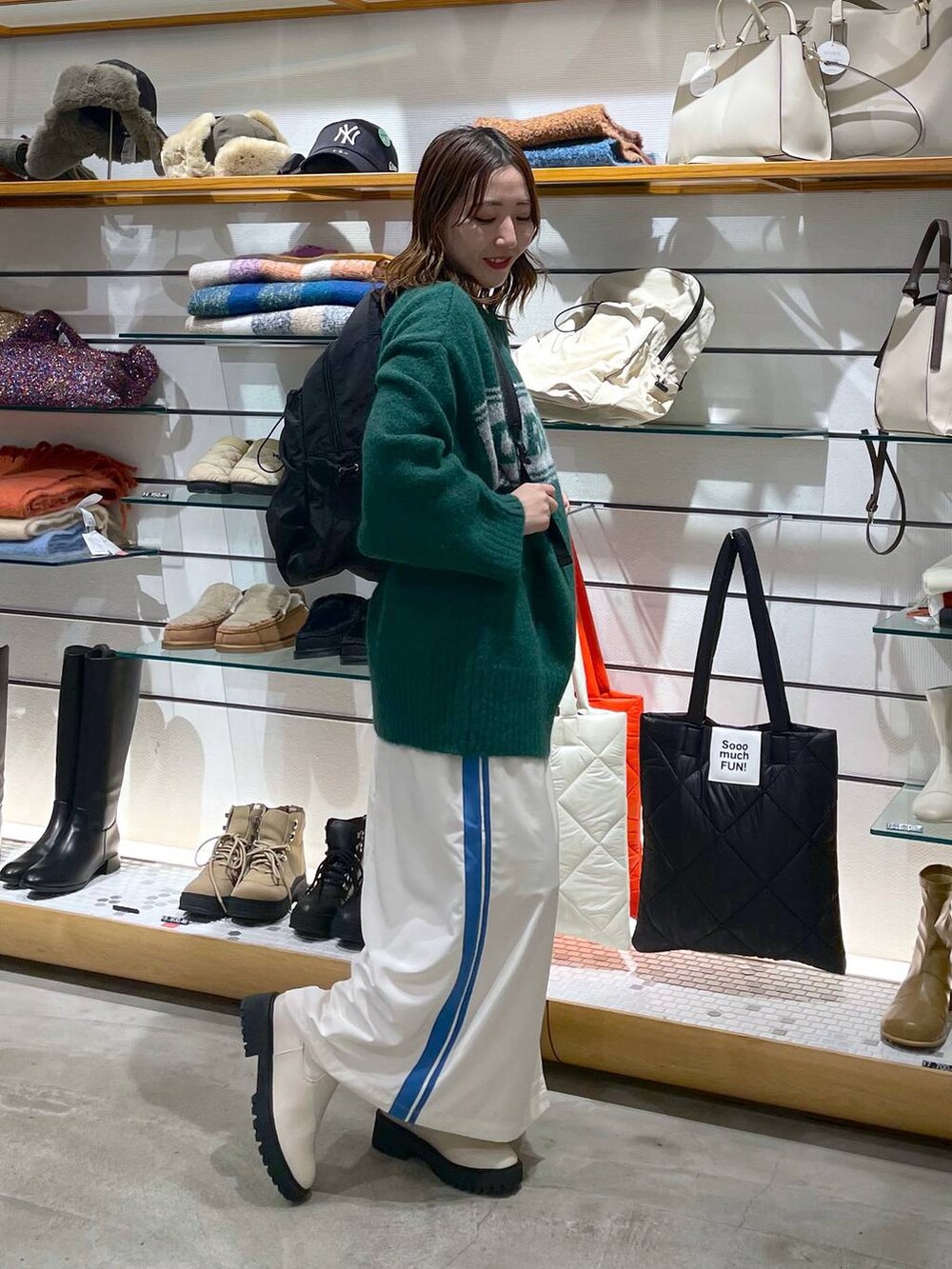 ホワイト系のブーツ、ブラック系のバックパック/リュック、ホワイト系のスカートを着用したレディースの冬コーディネートの3枚目の写真