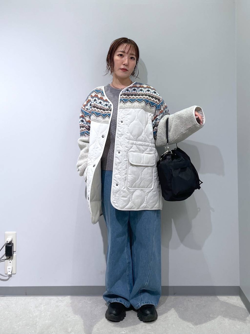 ブラック系のショルダーバッグ、グレー系のニット/セーター、ベージュ系のブルゾンを着用したレディースの冬コーディネートの2枚目の写真