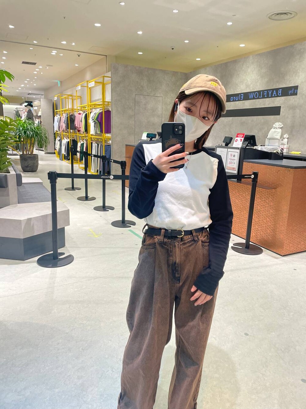 ブラウン系のデニムパンツ、ブラック系のTシャツ/カットソー、ブラック系のベルトを着用したレディースの秋コーディネートの2枚目の写真