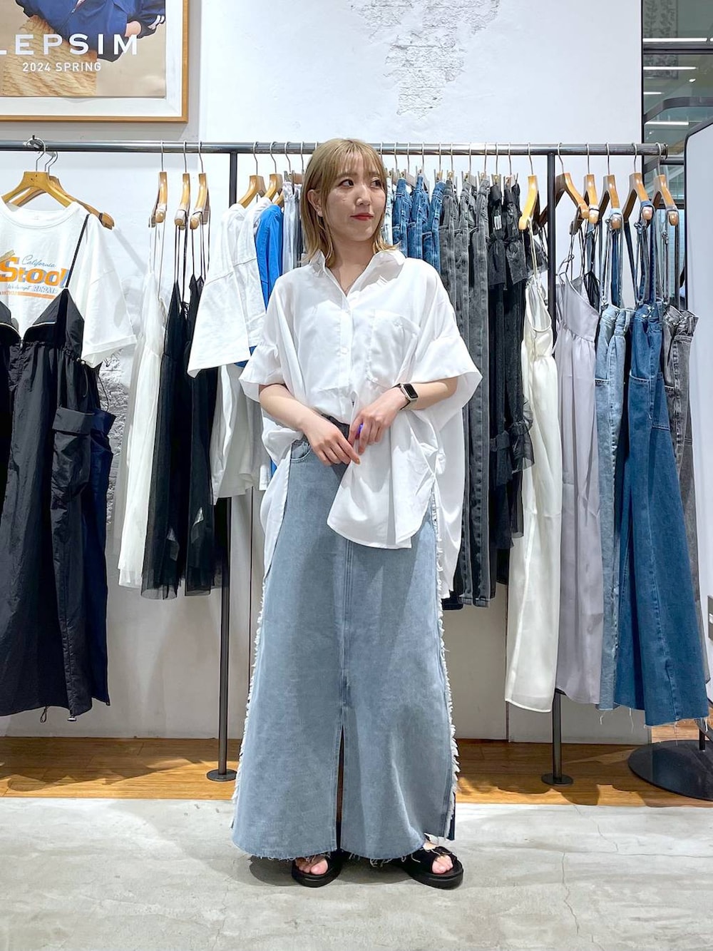ホワイト系のシャツ/ブラウス、ブルー系のデニムスカートを着用したレディースの春コーディネートの3枚目の写真