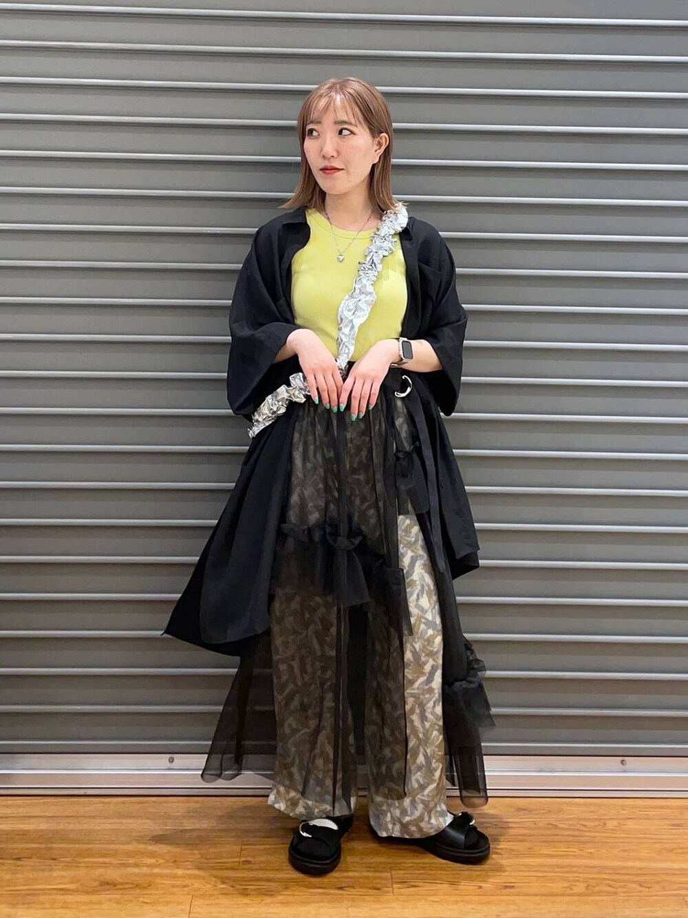 グレー系のその他パンツ、ブラック系のチュニック、ブラック系のサンダルを着用したレディースの春コーディネートの2枚目の写真