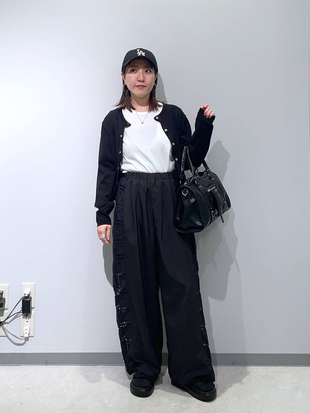 ブラック系のその他パンツ、ブラック系のサンダル、ブラック系のボストンバッグを着用したレディースの春コーディネートの3枚目の写真