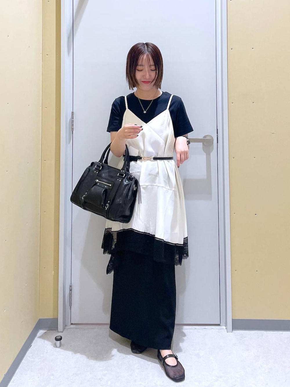 ブラック系のスカート、ブラック系のボストンバッグ、ブラック系のTシャツ/カットソーを着用したレディースの夏コーディネートの4枚目の写真