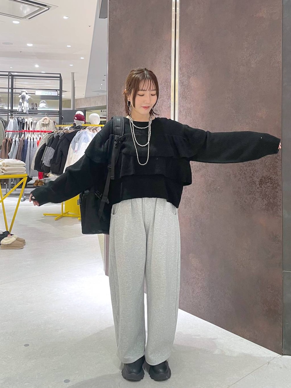 ブラック系のバックパック/リュック、グレー系のスウェットパンツ、ブラック系のニット/セーターを着用したレディースの冬コーディネートの3枚目の写真