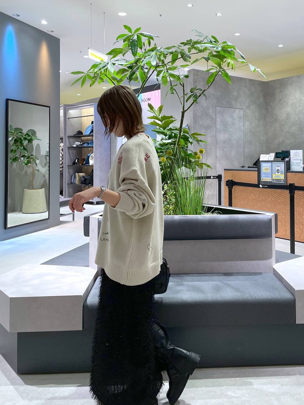 ブラック系のボストンバッグ、ブラック系のスカート、ベージュ系のカーディガン/ボレロを着用したレディースの秋コーディネートの2枚目の写真