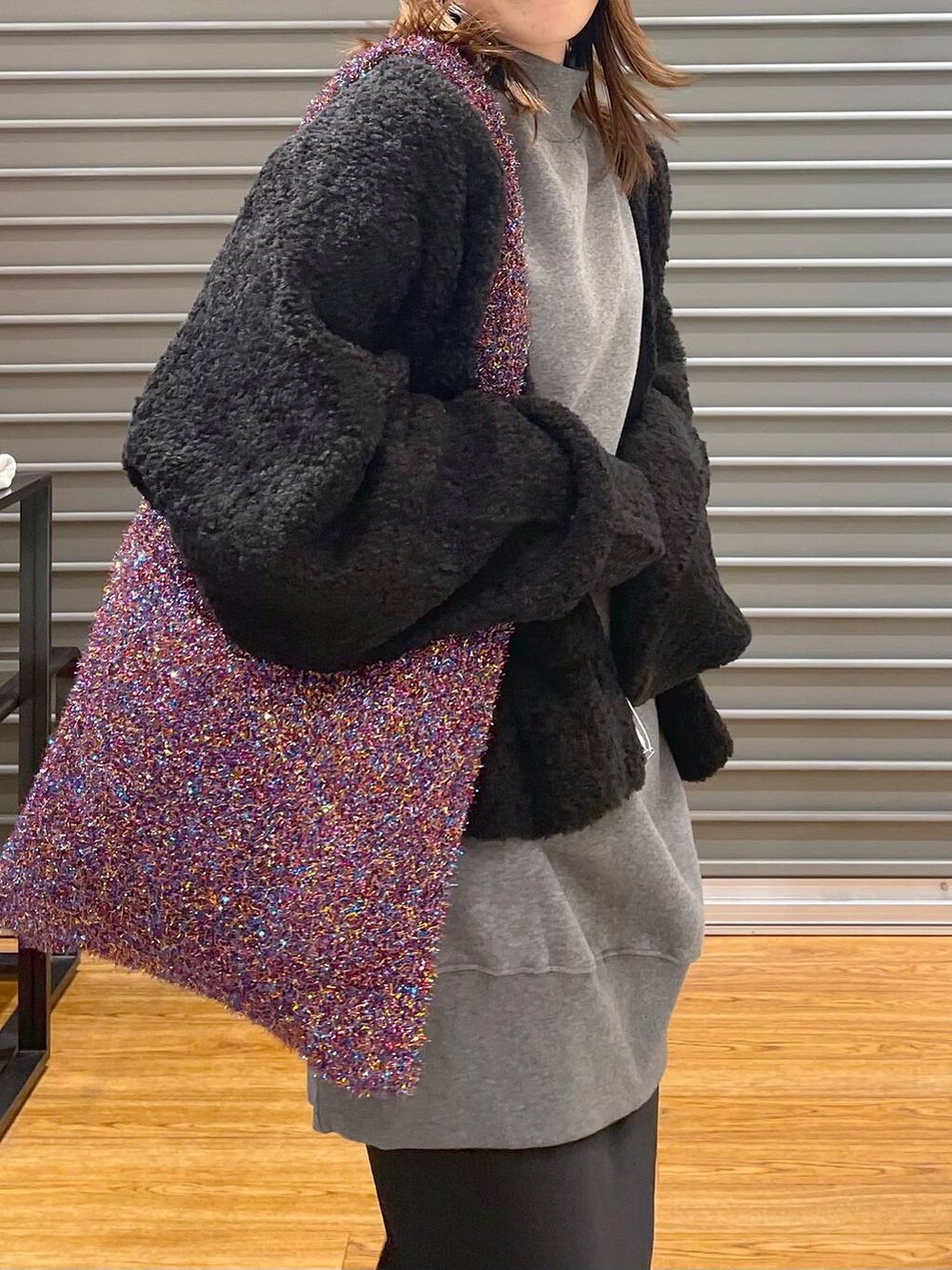 グレー系のチュニック、その他のショルダーバッグ、ブラック系のスカートを着用したレディースの冬コーディネートの3枚目の写真