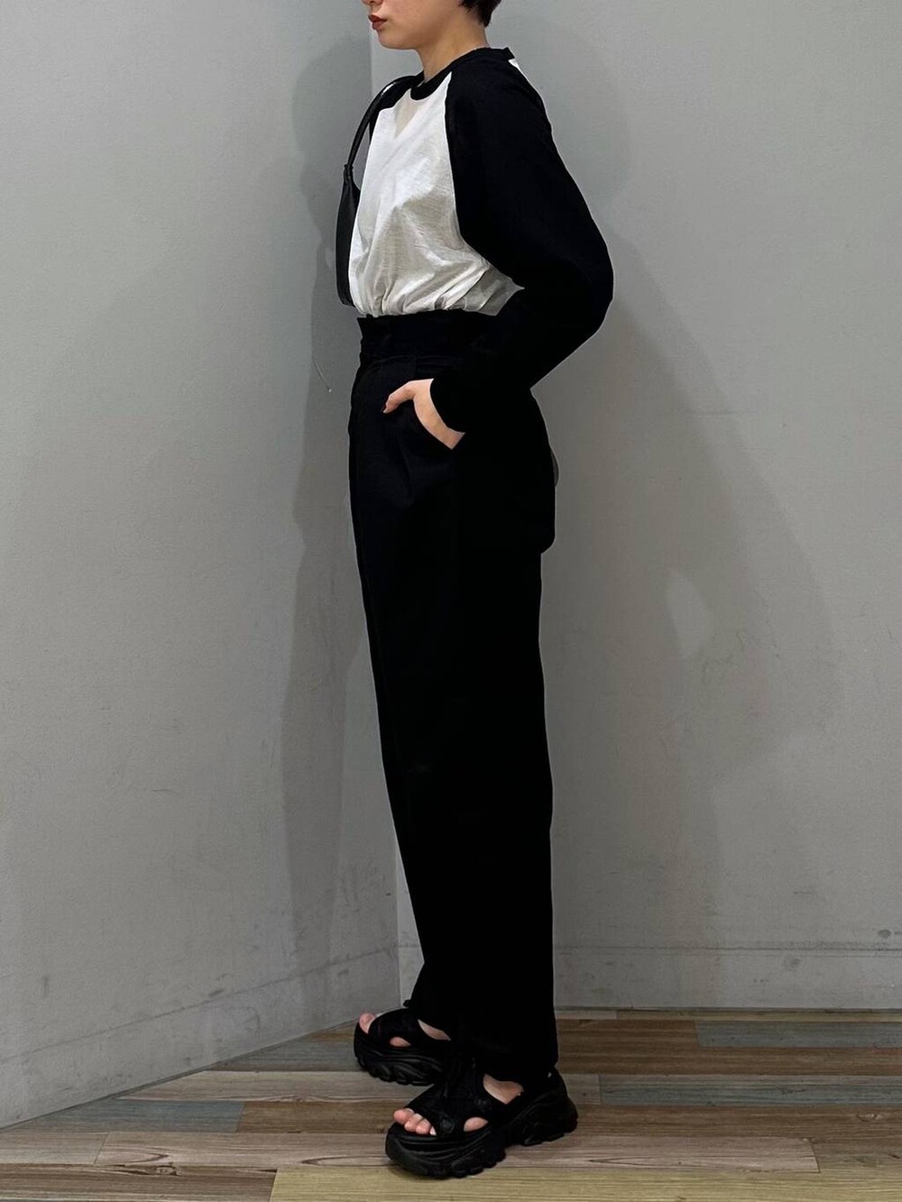 ブラック系のサンダル、ブラック系のハンドバッグ、ブラック系のTシャツ/カットソーを着用したレディースの春コーディネートの2枚目の写真