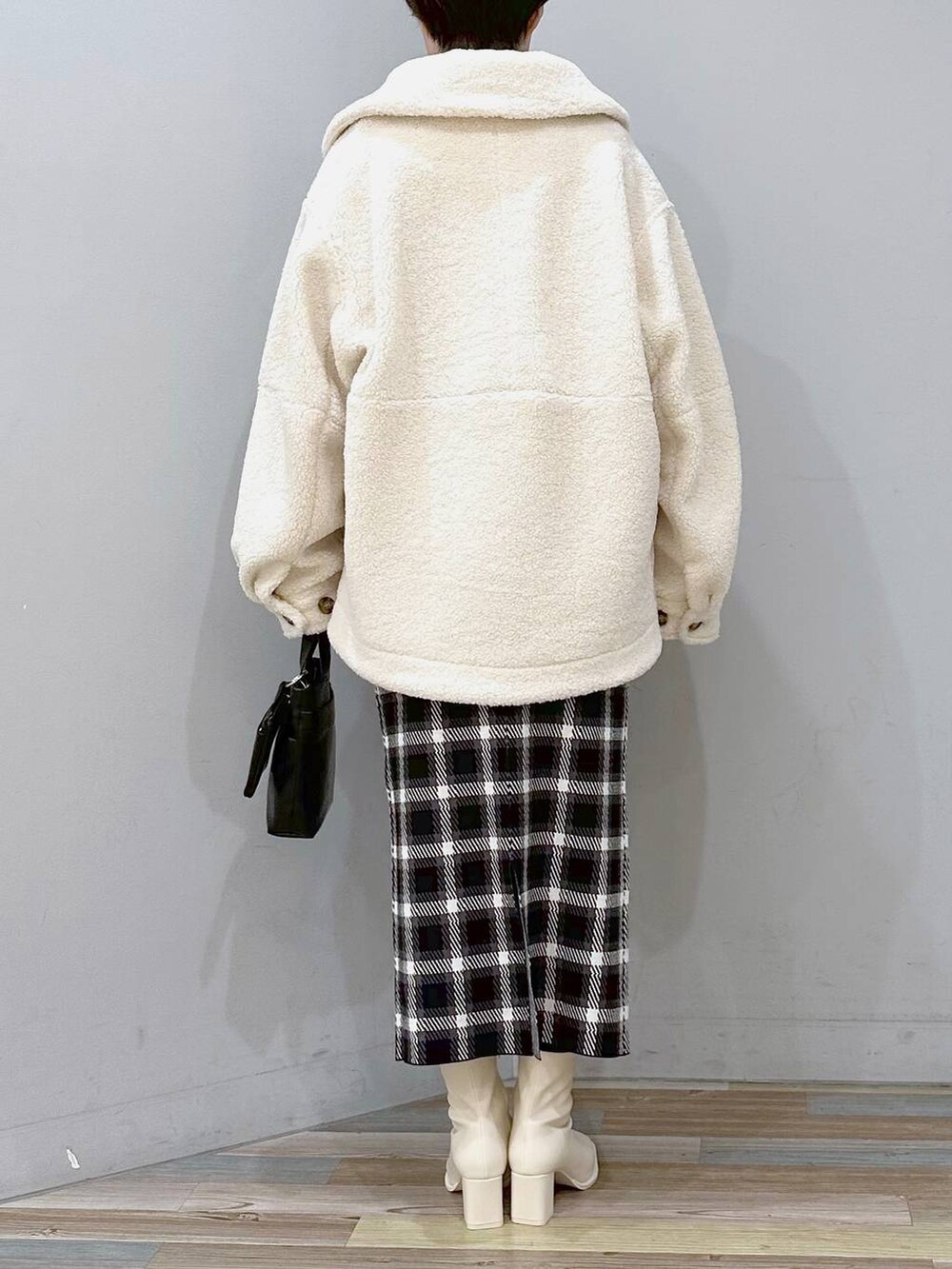 ホワイト系のニット/セーター、ホワイト系のブルゾン、ホワイト系のパンプスを着用したレディースの秋コーディネートの3枚目の写真