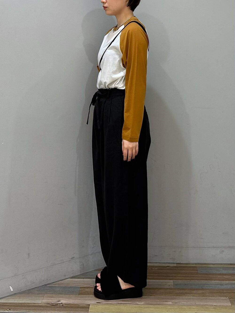 ブラック系のサンダル、ブラック系のショルダーバッグ、グレー系のスラックスを着用したレディースの春コーディネートの3枚目の写真