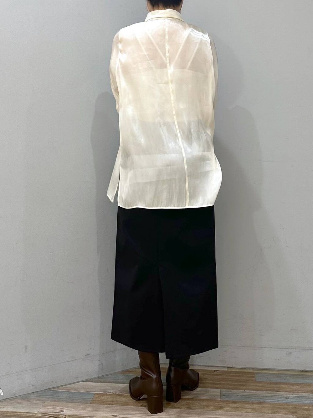 ホワイト系のキャミソール、ブラウン系のパンプス、ブラック系のスカートを着用したレディースの秋コーディネートの3枚目の写真