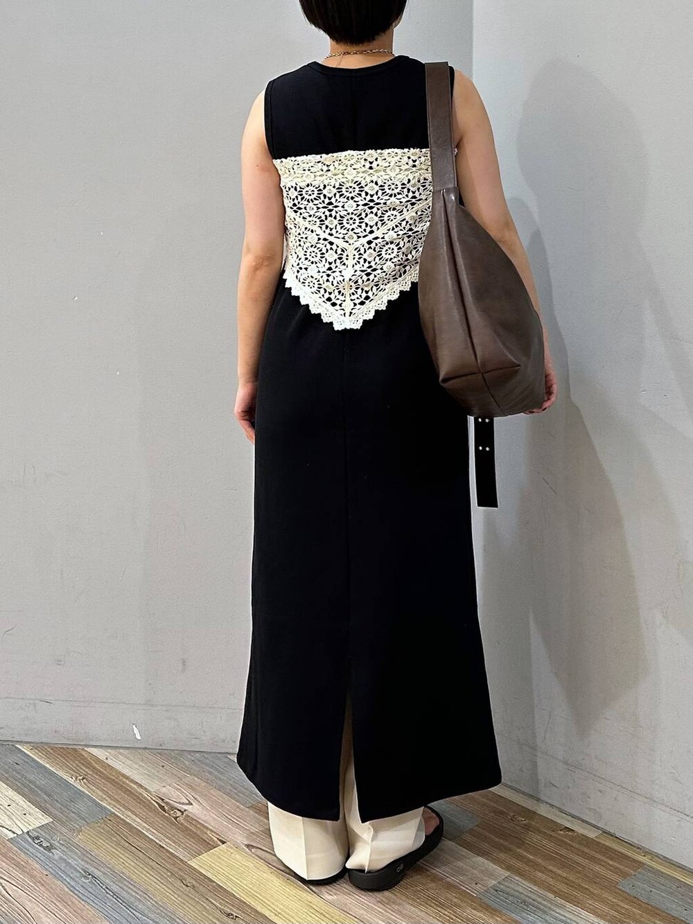 ホワイト系のスラックス、ブラウン系のボディバッグ/ウエストポーチ、ブラック系のワンピースを着用したレディースの夏コーディネートの4枚目の写真