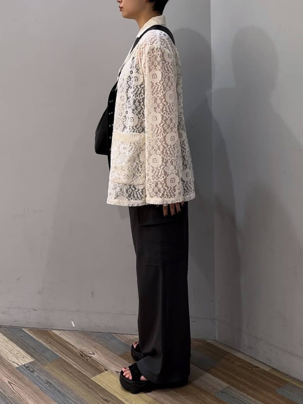 ブラック系のTシャツ/カットソー、ブラック系のボディバッグ/ウエストポーチ、ホワイト系のシャツ/ブラウスを着用したレディースの秋コーディネートの2枚目の写真