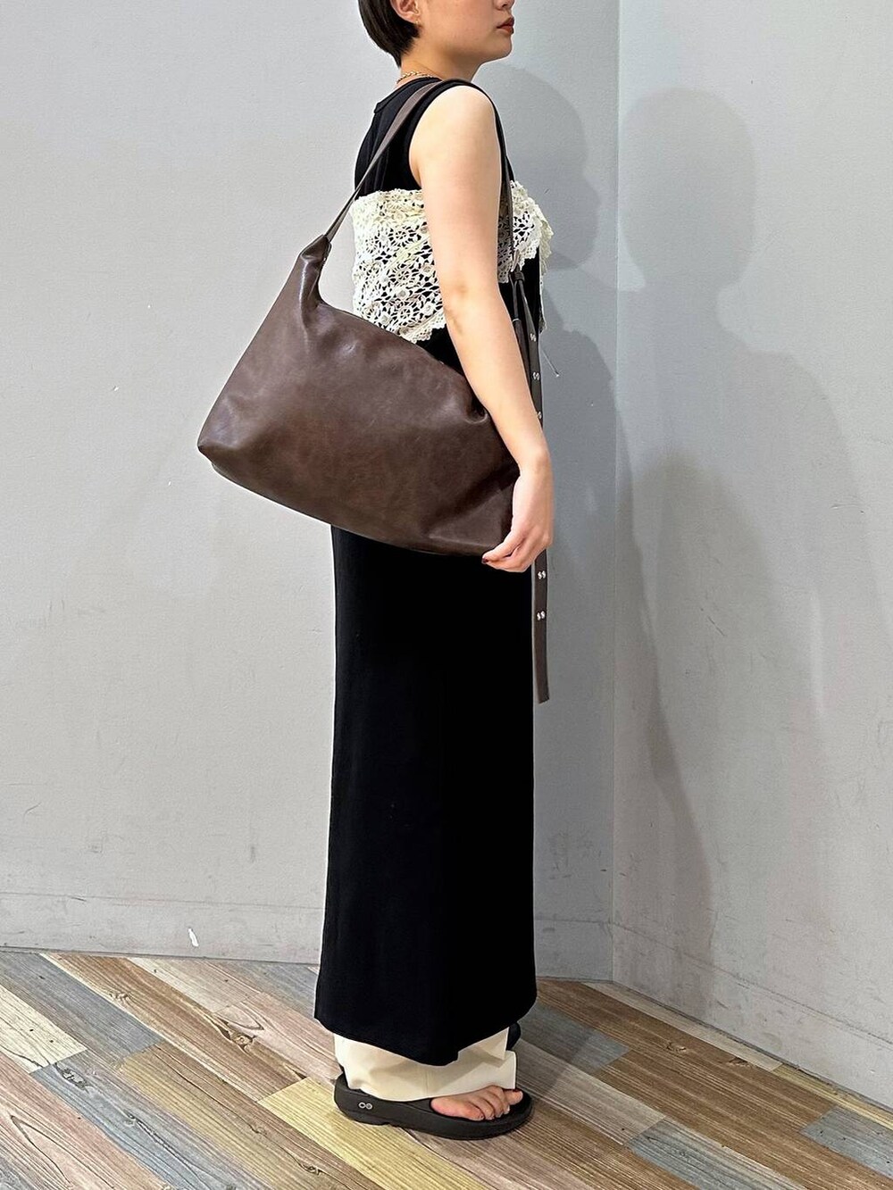 ホワイト系のスラックス、ブラウン系のボディバッグ/ウエストポーチ、ブラック系のワンピースを着用したレディースの夏コーディネートの3枚目の写真