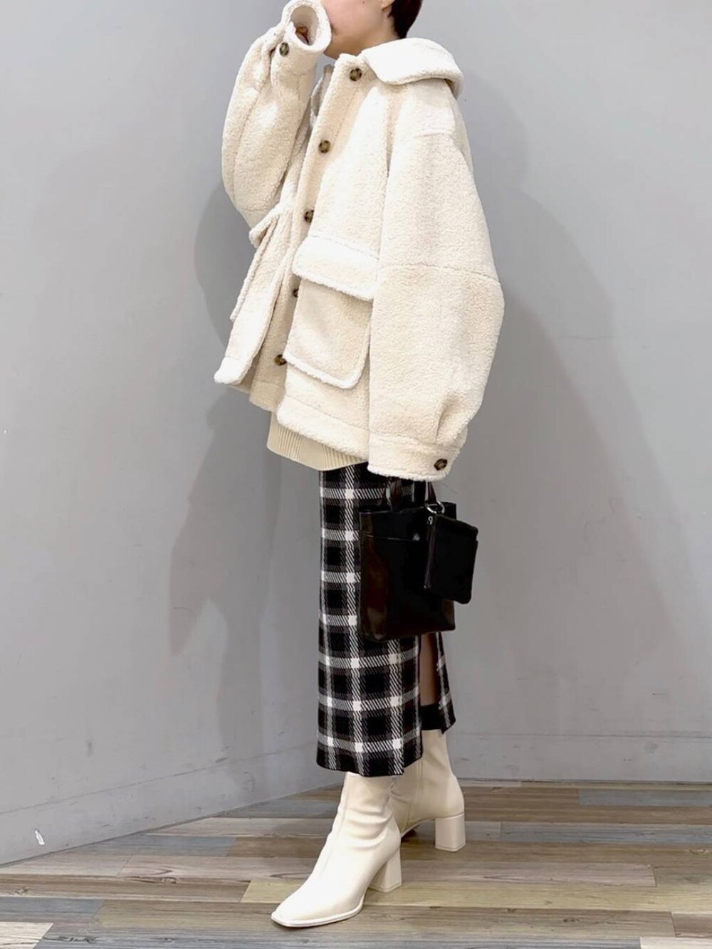 ホワイト系のニット/セーター、ホワイト系のブルゾン、ホワイト系のパンプスを着用したレディースの秋コーディネートの2枚目の写真