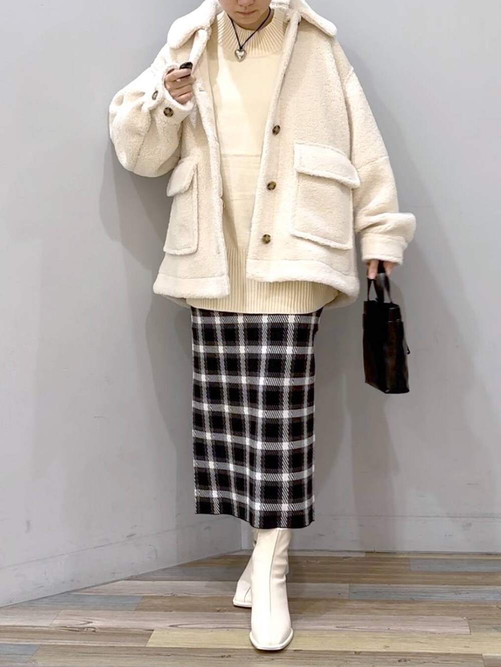 ホワイト系のニット/セーター、ホワイト系のブルゾン、ホワイト系のパンプスを着用したレディースの秋コーディネートの4枚目の写真