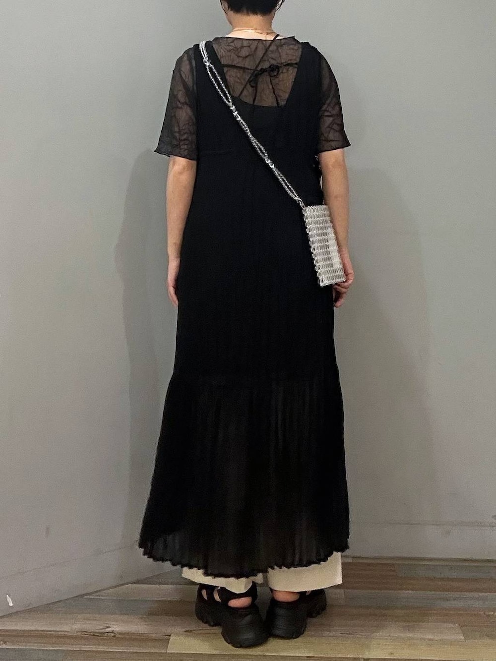 ブラック系のサンダル、ブラック系のワンピース、グレー系のTシャツ/カットソーを着用したレディースの春コーディネートの3枚目の写真