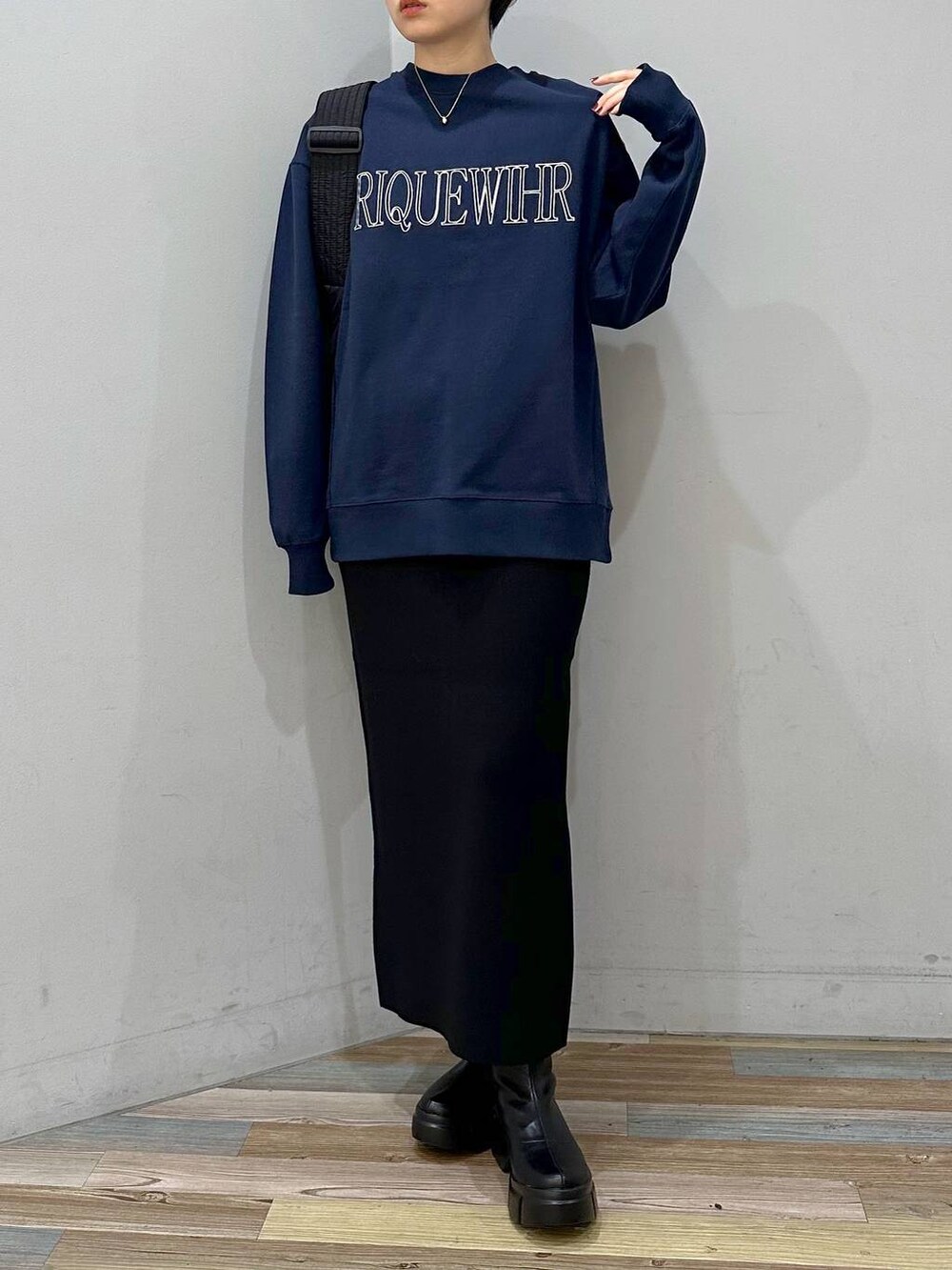 ブラック系のショルダーバッグ、ブルー系のスウェット、ブラック系のスカートを着用したレディースの秋コーディネートの2枚目の写真